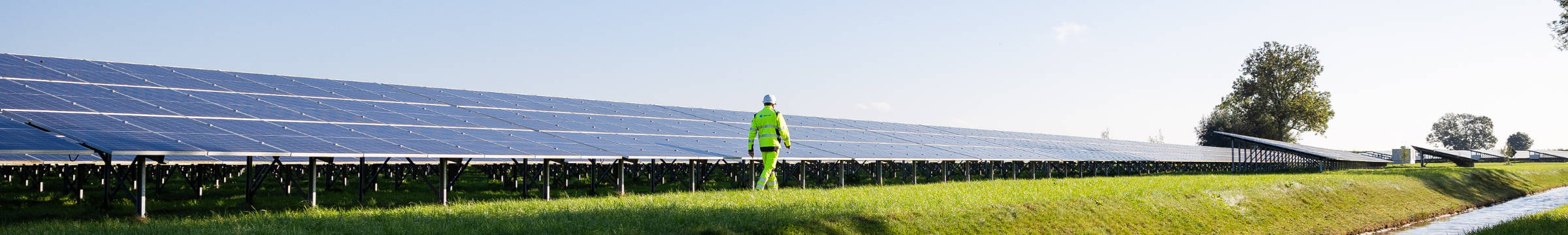 Čovjek hoda pored solarne ploče